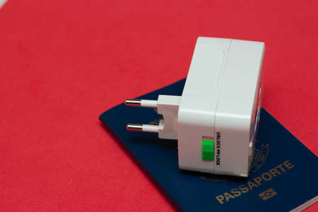 universal socket adapter over a passport with colored backgroundの写真素材