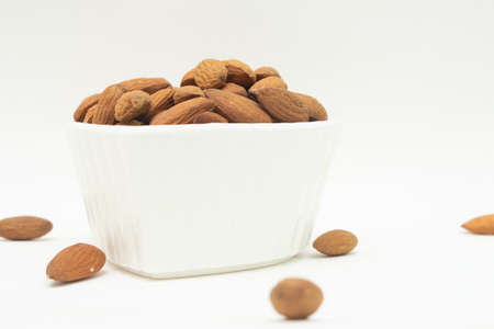 small white bowl full of almondsの写真素材