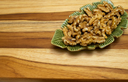 green bowl full of nuts on the wooden tableの写真素材