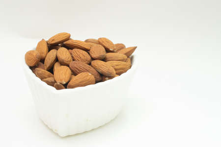 small white bowl full of almondsの写真素材