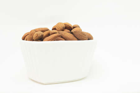 small white bowl full of almondsの写真素材