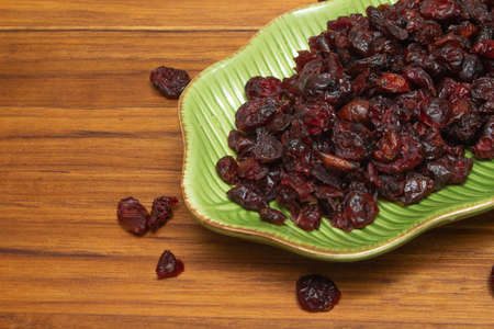 green bowls full of cranberries and nuts on the wooden tableの写真素材