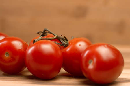 several small tomatoes on a wooden tableの写真素材
