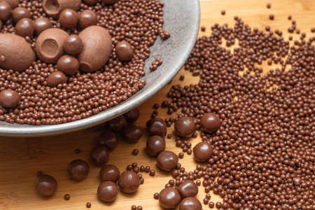 different types of chocolate balls in a gray bowl on a wooden table