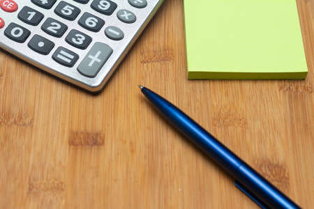 calculator near notepad under white table - office