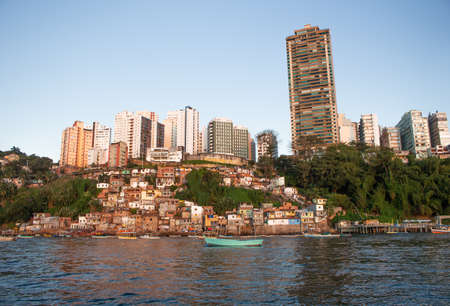 SALVADOR, BRASIL - JULY 30, 2022 : view of several buildings and houses close and several boats in...