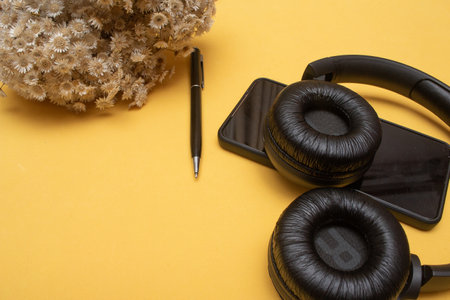 cellphone and headset on table on yellow background - officeの写真素材
