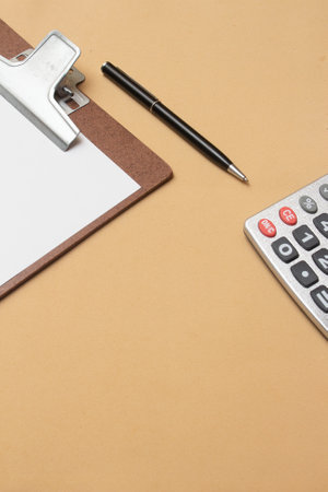 calculater and clipboard on beige table - office