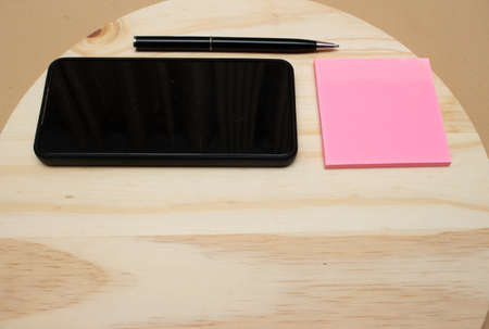 smartphone and pen near notepad on desk- officeの写真素材