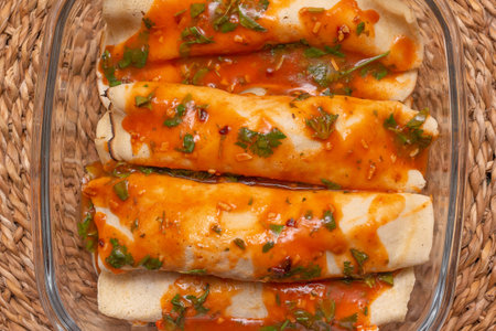 top view of chicken pancakes topped with tomato sauce filled with basil leaves in glass bowl