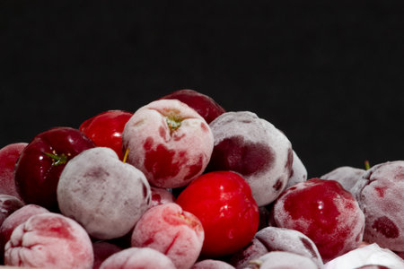 bowl full of frozen and fresh acerolas and black backgroundの写真素材