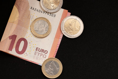 ten euro banknote with coins on a black backgroundの写真素材