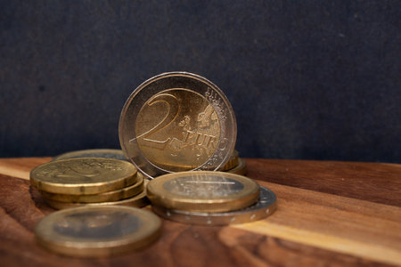 two euros and several coins on the wooden backgroundの写真素材