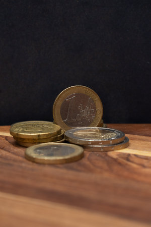 one euro and several coins on the wooden background