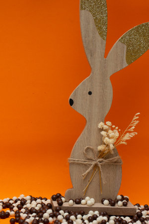 easter bunny on an orange background and litte chocolate balls (Easter)