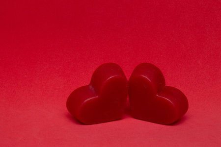 two red hearts on a red background (valentine's day)の写真素材