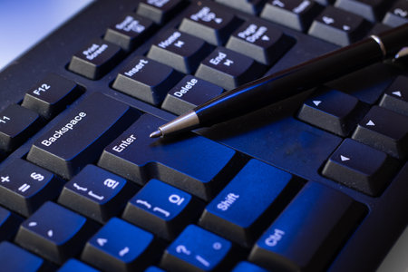 pen on a keyboard at the officeの写真素材