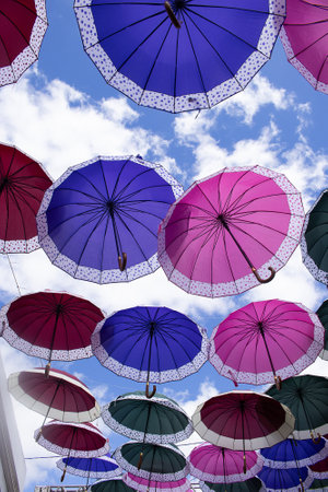 several colorful parasols hanging on a sunny dayの写真素材