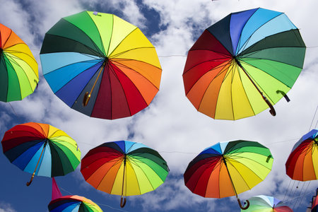 several colorful parasols hanging on a sunny dayの写真素材