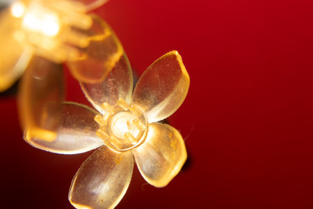 macro of a golden flower with a red background - christmas ornamentsの写真素材