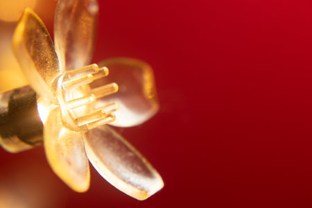 macro of a golden flower with a red background - christmas ornamentsの写真素材