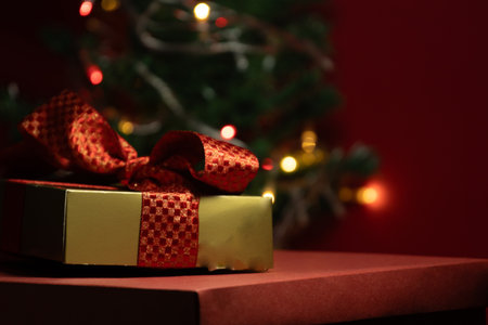 gift box with a Christmas tree in backgroundの写真素材