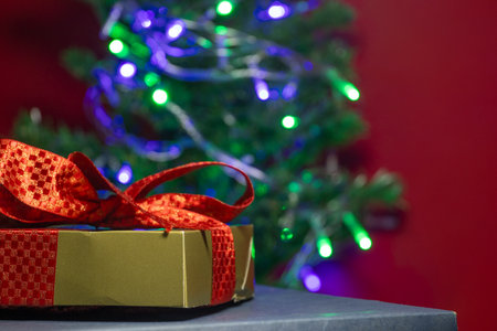 gift box with a Christmas tree in backgroundの写真素材