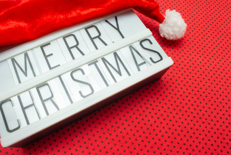 luminous sign with Santa hat written "Merry Christmas" on a red backgroundの写真素材