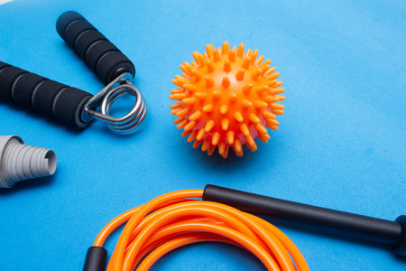 mini ball, elastic band and other gym equipment on a blue backgroundの写真素材