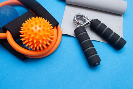 mini ball, elastic band and other gym equipment on a blue backgroundの写真素材