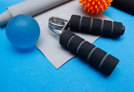 mini ball, elastic band and other gym equipment on a blue backgroundの写真素材