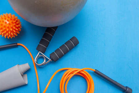 mini ball, elastic band and other gym equipment on a blue backgroundの写真素材