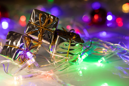 colored christmas lights with several gift boxesの写真素材