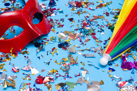 Carnival mask and confetti on blue background. Flat lay.の写真素材