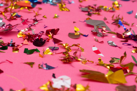 Colorful confetti on pink background. Festive decoration concept.の写真素材