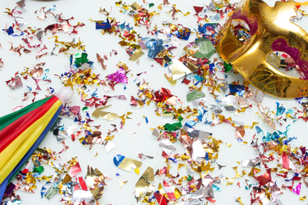 Colorful confetti and carnival mask on a white background.の写真素材