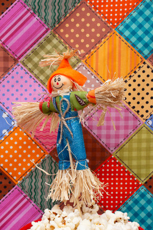 Carnival scarecrow with popcorn on a colorful patchwork backgroundの写真素材