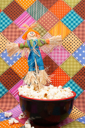 Popcorn with scarecrow in a red bowl on a colorful backgroundの写真素材