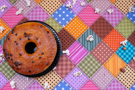 Donut with chocolate glaze on a colorful patchwork background.の写真素材