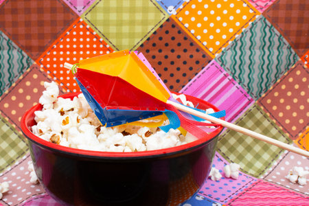 Popcorn and kite in a red bowl on a colorful backgroundの写真素材