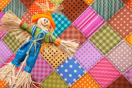 Colorful patchwork background with a rag doll on a quiltの写真素材