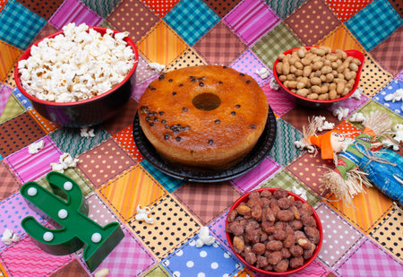Chocolate donut with nuts and candies on colorful tableclothの写真素材