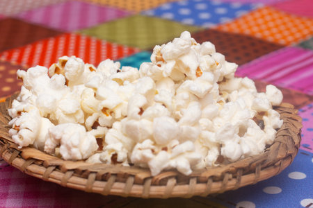 Popcorn in a basket on a tablecloth. Selective focus.の写真素材