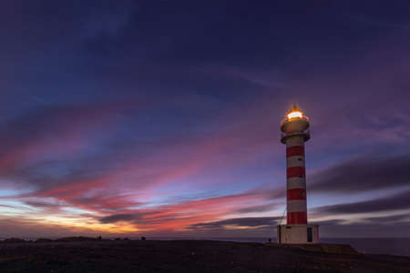 lighthouse illuminated at duskの写真素材
