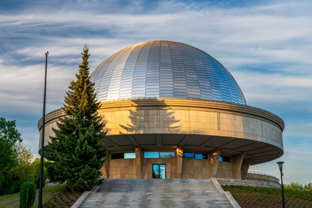 The dome of the Silesian planetarium shining in the light of the setting sun. Aluminum panels on the roof of the planetariumのeditorial素材