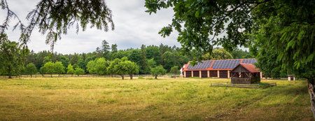 Panorama of the run for horses. Brick barn with photovoltaic panels on a corrugated roof. Beautiful rural landscape. Zwierzyniec, Polandのeditorial素材