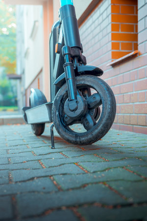 Electric scooter parked on a cobblestone walkwayの写真素材