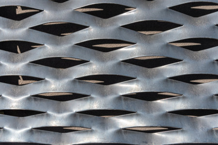 Perforated metal sheet stamping plate texture - front view. Light reflection and shadow.