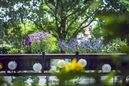 Lovely little balcony full of greenery. Plants in pots hung on the balustrade and solar lamps. Springの写真素材