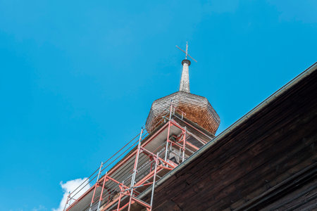 Renovation of an old historic wooden church. Scaffolding erected next to the church tower.の写真素材
